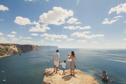 family overlooking ocean from cliff
