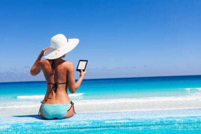 Woman reading from Kindle on the beach