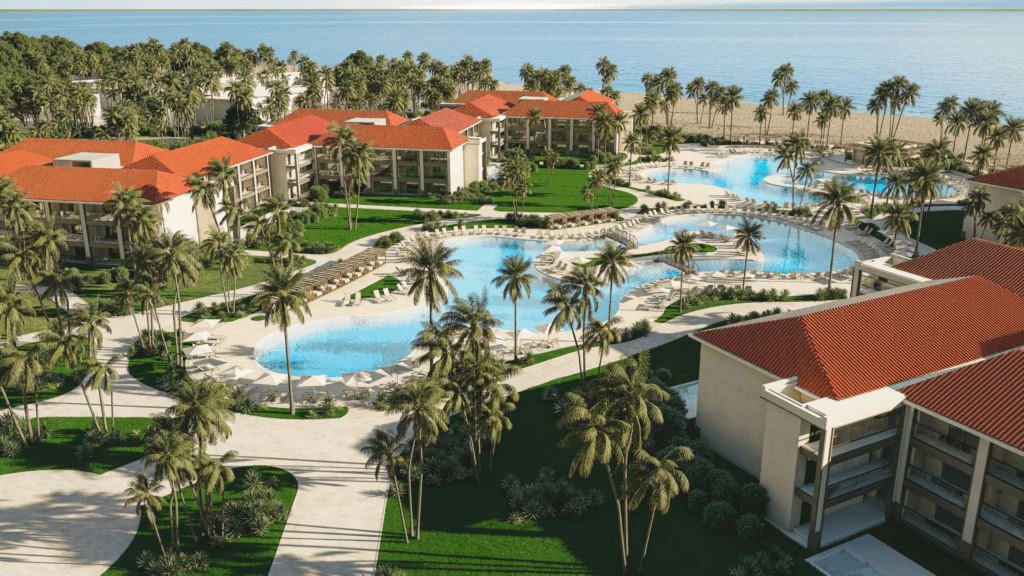 Hyatt Vivid Punta Cana aerial view of resort pools, palm tree grounds, red-roof villas, and beachfront