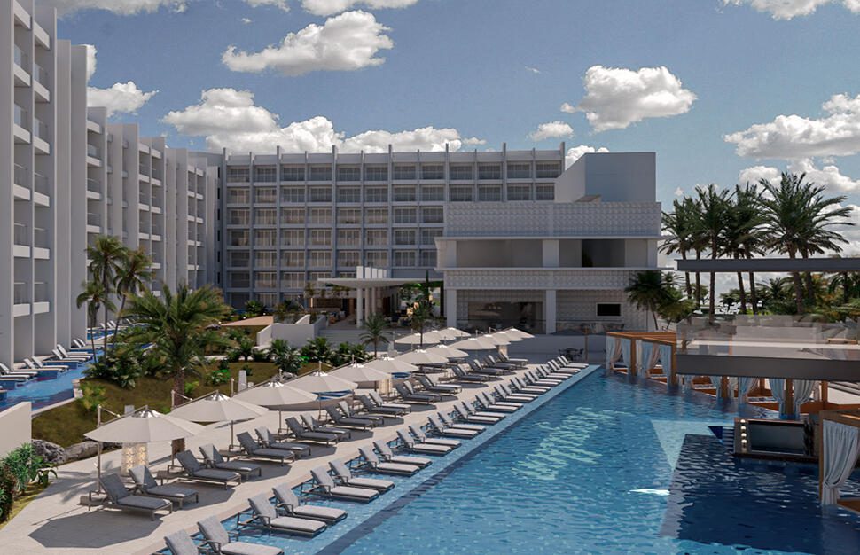 Royalton Vessence Barbados resort pool area with lounge chairs, umbrellas, and modern white hotel exterior
